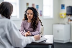 distressed young woman talking with psychotherapist